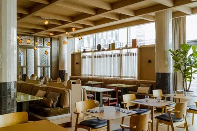 a restaurant with tables and chairs and windows at PURO Kraków Stare Miasto in Kraków