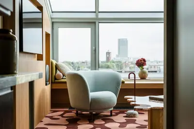 a living room with a chair in front of a window at PURO Kraków Stare Miasto in Kraków