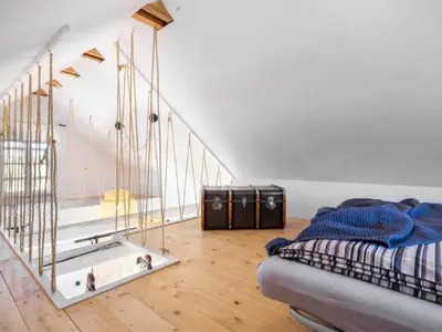 a room with a bed and a staircase with a mirror at Chatka w trawach in Kraków