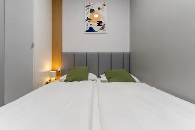 a bedroom with two beds and a red table at Szewska 7 Apartments in Kraków