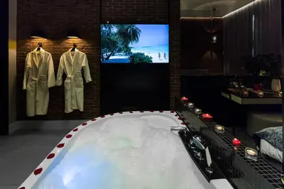 a bathroom with a bath tub with a tv in it at Starowiślna VIP Apartamenty JACUZZI in Kraków