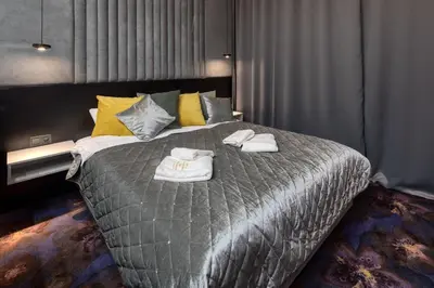 a bedroom with a large bed with towels on it at Starowiślna VIP Apartamenty JACUZZI in Kraków