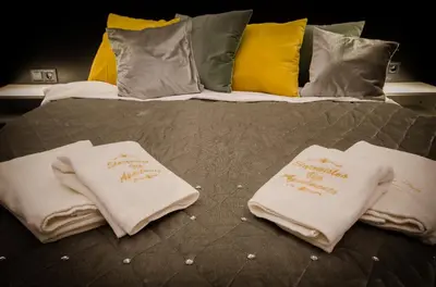 a bed with two white towels on top of it at Starowiślna VIP Apartamenty JACUZZI in Kraków