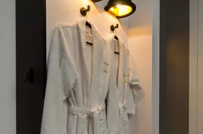 a white coat hanging on a rack in a room at Starowiślna VIP Apartamenty JACUZZI in Kraków