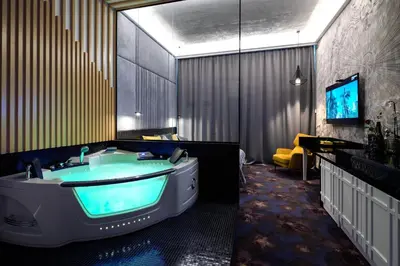 a bathroom with a tub with a tv in it at Starowiślna VIP Apartamenty JACUZZI in Kraków