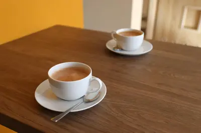 two cups of coffee sitting on a wooden table at Róża Pustyni in Chrzanów