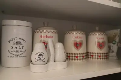 a shelf with a bunch of white cups on it at Róża Pustyni in Chrzanów