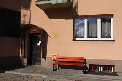 a red bench sitting in front of a building at Róża Pustyni in Chrzanów