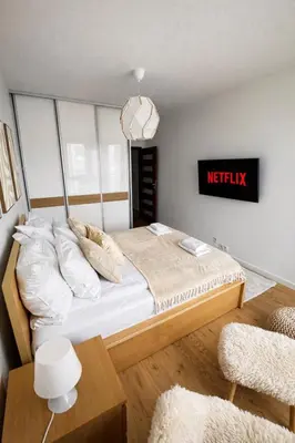 a bedroom with a king sized bed with a netflix sign at InPoint Mogilska Tower City View Apartments near Tauron Arena Self Check-in in Kraków