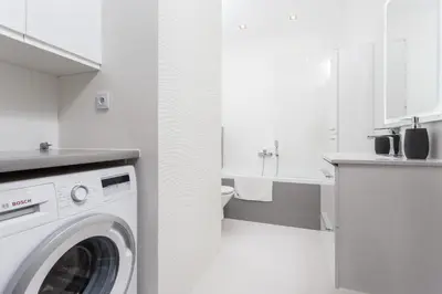 a white kitchen with a washing machine in it at InPoint Mogilska Tower City View Apartments near Tauron Arena Self Check-in in Kraków