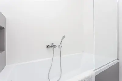 a shower in a bathroom with a glass wall at InPoint Mogilska Tower City View Apartments near Tauron Arena Self Check-in in Kraków
