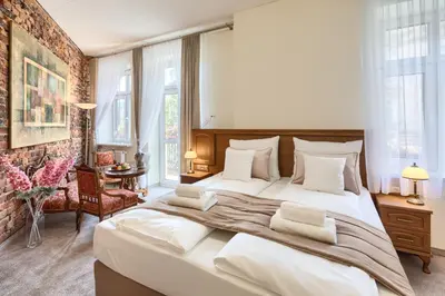 a large white bed in a room with windows at Apartamenty Pod Baranem in Kraków