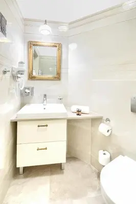 a white bathroom with a sink and a toilet at Apartamenty Pod Baranem in Kraków