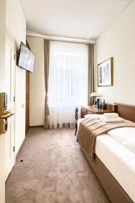 a hotel room with a large bed and a window at Apartamenty Pod Baranem in Kraków