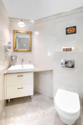 a white bathroom with a toilet and a sink at Apartamenty Pod Baranem in Kraków