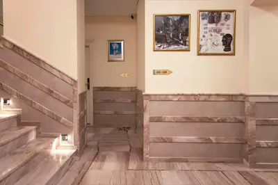 a hallway with wooden stairs and pictures on the wall at Apartamenty Pod Baranem in Kraków