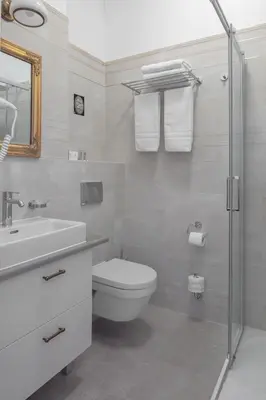 a white bathroom with a toilet and a sink at Apartamenty Pod Baranem in Kraków