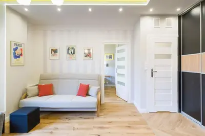 a living room with a white couch and red pillows at Apartament przy Parku Krakowskim in Kraków