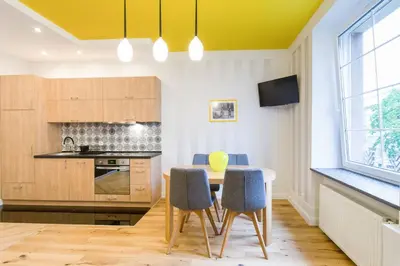 a kitchen with a table and chairs in a room at Apartament przy Parku Krakowskim in Kraków