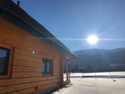 a building with the sun in the sky behind it at Miętusowa Chata pod Babią in Zawoja