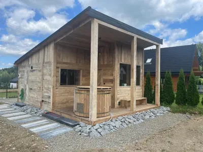 a large wooden building with a tub in it at Miętusowa Chata pod Babią in Zawoja