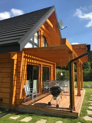 a house with a deck with a grill on it at Miętusowa Chata pod Babią in Zawoja