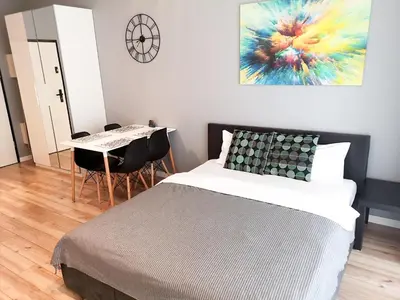 a bedroom with a bed and a table with chairs at NOVUM Apartment with Parking in Kraków