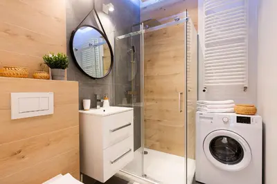 a bathroom with a washing machine and a mirror at NOVUM Apartment with Parking in Kraków