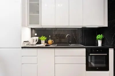 a kitchen with white cabinets and a sink at NOVUM Apartment with Parking in Kraków