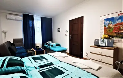 a bedroom with a bed with a blue comforter at GAJ Apartment - Air condition, free parking in Kraków