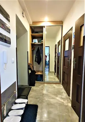 a hallway with a door leading to a hallway with white plates at GAJ Apartment - Air condition, free parking in Kraków