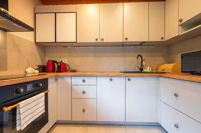 a kitchen with white cabinets and a stove at Willa Lavinka z sauną in Zawoja