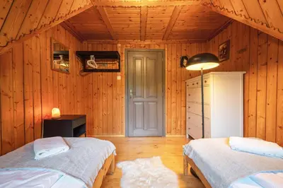 a bedroom with two beds in a wooden room at Willa Lavinka z sauną in Zawoja