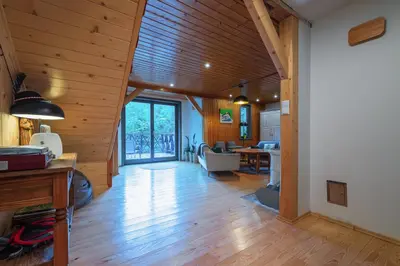 a living room with wooden walls and a wooden floor at Willa Lavinka z sauną in Zawoja