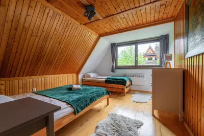 a bedroom with two beds and a window at Willa Lavinka z sauną in Zawoja