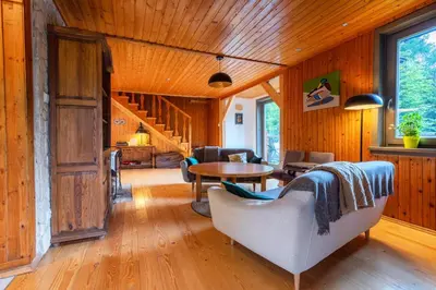 a living room with wooden walls and a wooden floor at Willa Lavinka z sauną in Zawoja