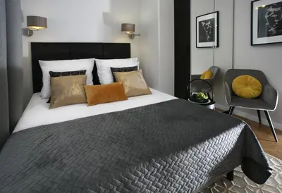 a bedroom with a large bed and a chair at Gem Apartment by Castle (Old Town Krakow) in Kraków