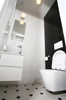 a bathroom with a white toilet and a sink at Gem Apartment by Castle (Old Town Krakow) in Kraków