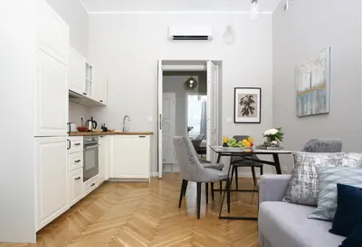 a kitchen and living room with a table and a couch at Gem Apartment by Castle (Old Town Krakow) in Kraków
