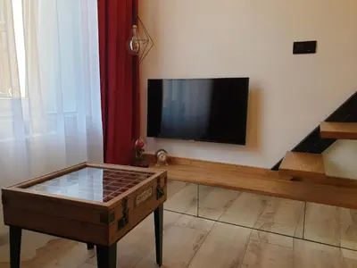 a living room with a flat screen tv and a coffee table at LOFT-to-be Apartment in Kraków