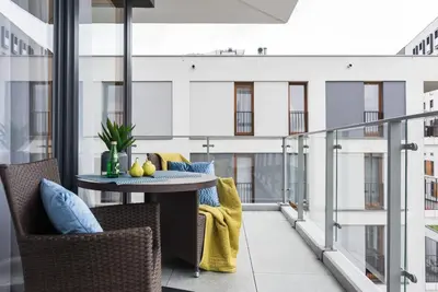 a balcony with a table and chairs on a building at NEARTOpl Rakowicka apartments Parking in Kraków