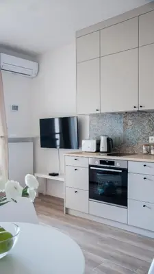a kitchen with white cabinets and an oven at NEARTOpl Rakowicka apartments Parking in Kraków