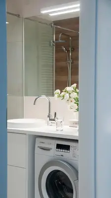 a bathroom with a washing machine and a sink at NEARTOpl Rakowicka apartments Parking in Kraków
