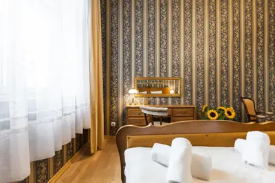 a bedroom with a bed and a desk and a wall at Vintage Senacka 5 Apartments in Kraków
