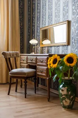 a desk with a chair and a vase with sunflowers at Vintage Senacka 5 Apartments in Kraków