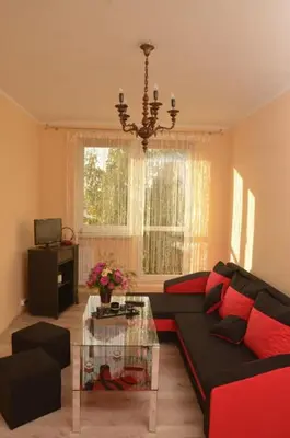 a living room with a couch and a glass table at Apartament Skałka in Jaworzno