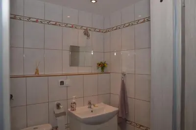 a white bathroom with a sink and a toilet at Apartament Skałka in Jaworzno