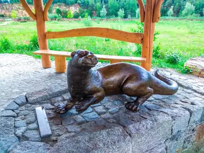 a statue of a dog sitting next to a chair at Apartament Skałka in Jaworzno