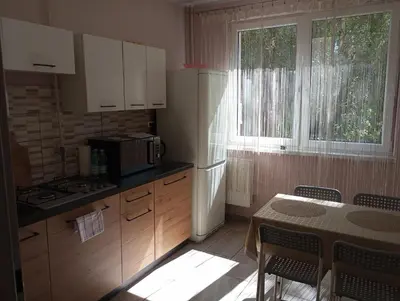 a kitchen with a table and a white refrigerator at Apartament Skałka in Jaworzno