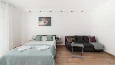 a white room with two beds and a couch at Wiślane Tarasy, Sun & Snow in Kraków
